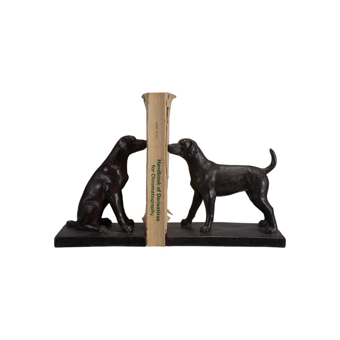 Black bookends shaped like dogs holding book on a white background