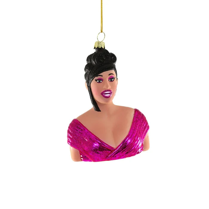 A Christmas tree ornament shaped like a woman with an updo hairstyle, wearing a shiny pink dress and pink lipstick, hanging by a gold string.
