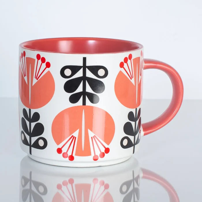 Mid-century style mug with coral and black floral patterns and a coral-colored handle and interior.