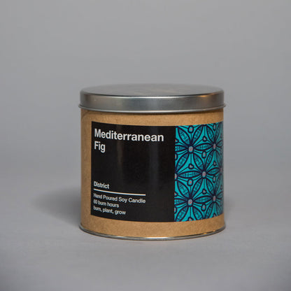 Small tin container candle with Mediterranean fig scent and decorative blue geometric pattern on label