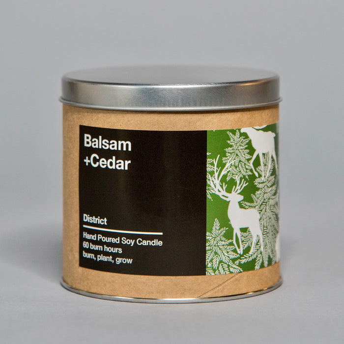 Hand poured soy candle with balsam and cedar scent in a rustic tin featuring deer and pine tree design
