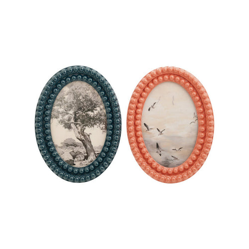 Two oval picture frames with nature-themed designs on a white background