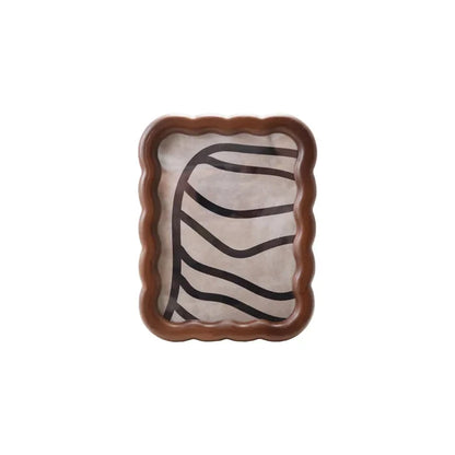 Wooden scalloped-edge photo frame with a smooth finish holding abstract black line artwork on neutral background