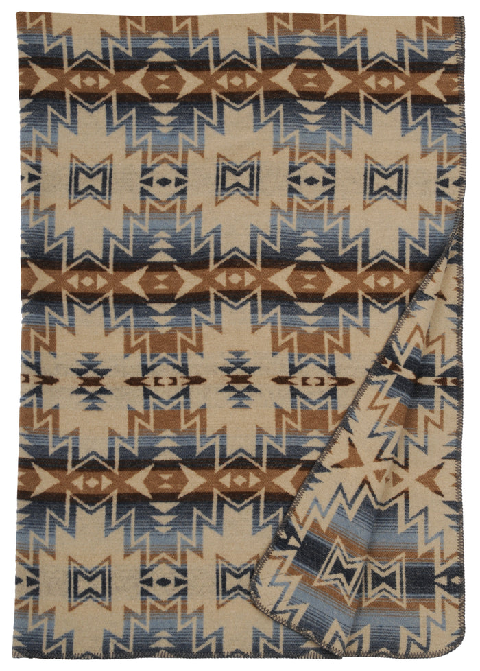 Beige, blue, and brown geometric patterned washable wool blanket with a folded corner showing its soft texture.