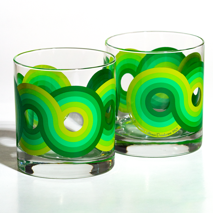 Pair of clear rocks glasses with bright green and yellow concentric circle patterns on the exterior surface
